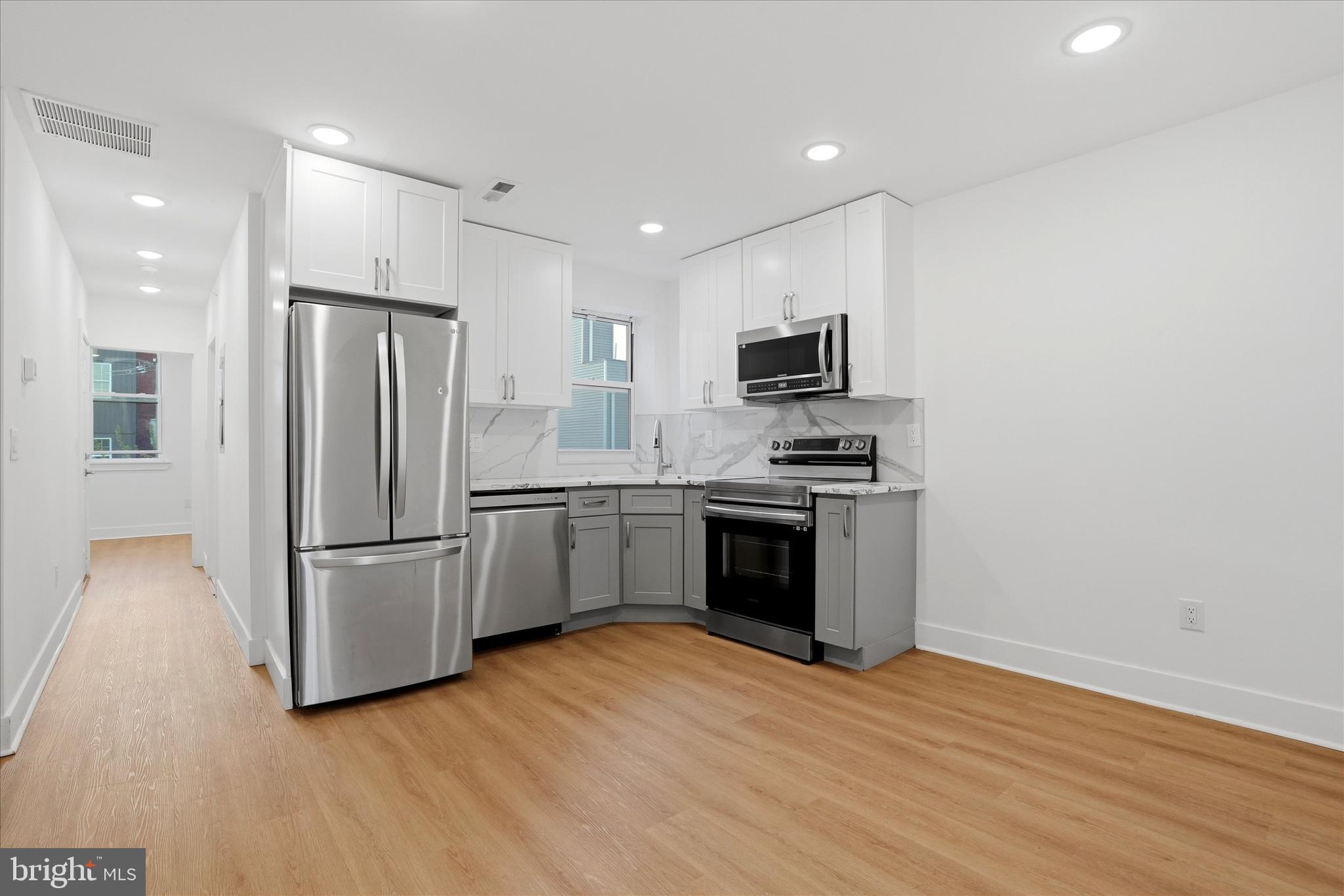 2104 North 8th Street, Unit 3 Philadelphia, PA 19122 - Photo 3 of 15 a kitchen with a refrigerator and a stove top oven