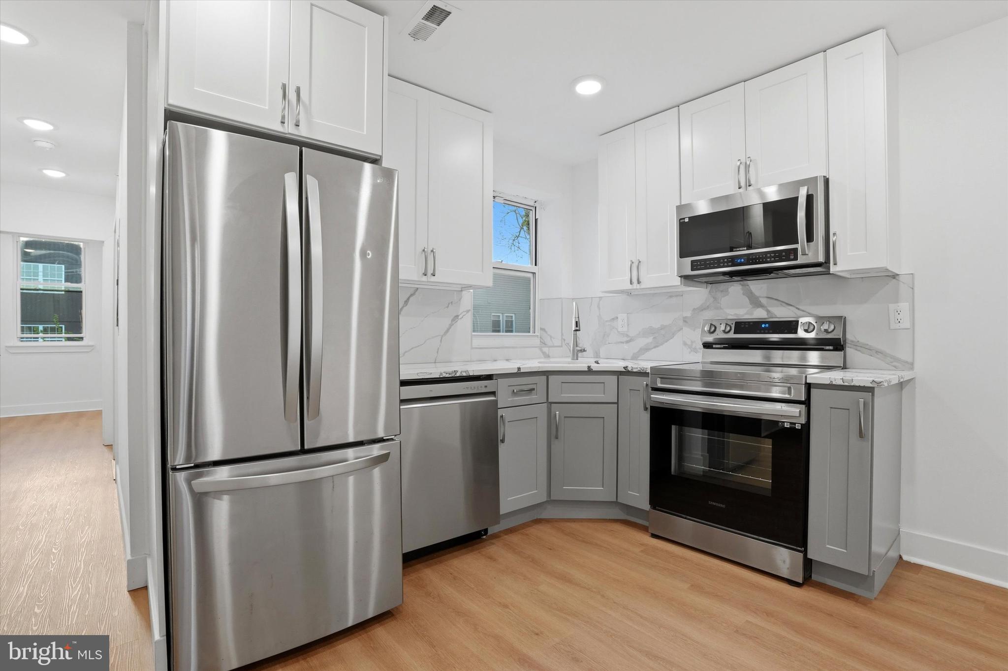 2104 North 8th Street, Unit 3 Philadelphia, PA 19122 - Photo 6 of 15 a kitchen with stainless steel appliances a refrigerator stove and microwave