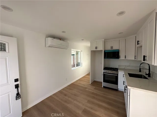 a kitchen with granite countertop a refrigerator and a stove top oven