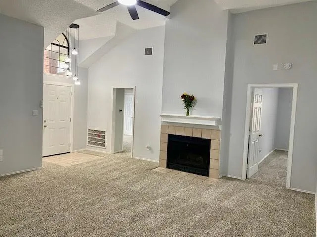 an empty room with windows and fireplace