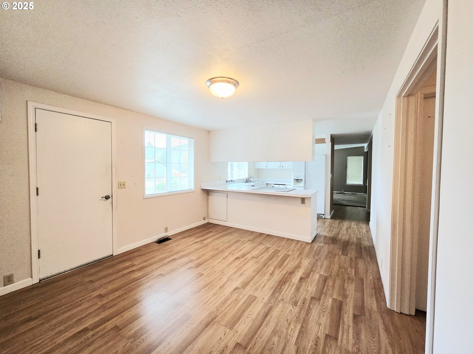 239 Arrow Way Myrtle Creek, OR 97457 - Photo 3 of 25 a view of an empty room with wooden floor and a window