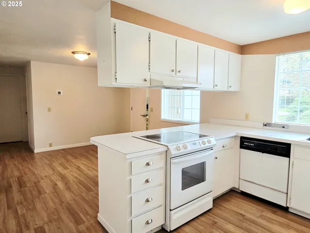 a kitchen with cabinets appliances a sink and a window