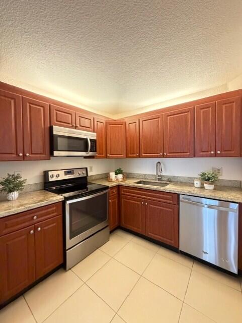 a large kitchen with stainless steel appliances granite countertop a stove sink and cabinets