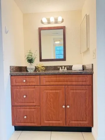 a bathroom with a sink vanity and mirror