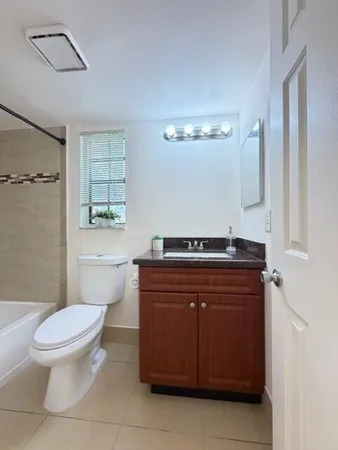 a bathroom with a toilet a sink and mirror
