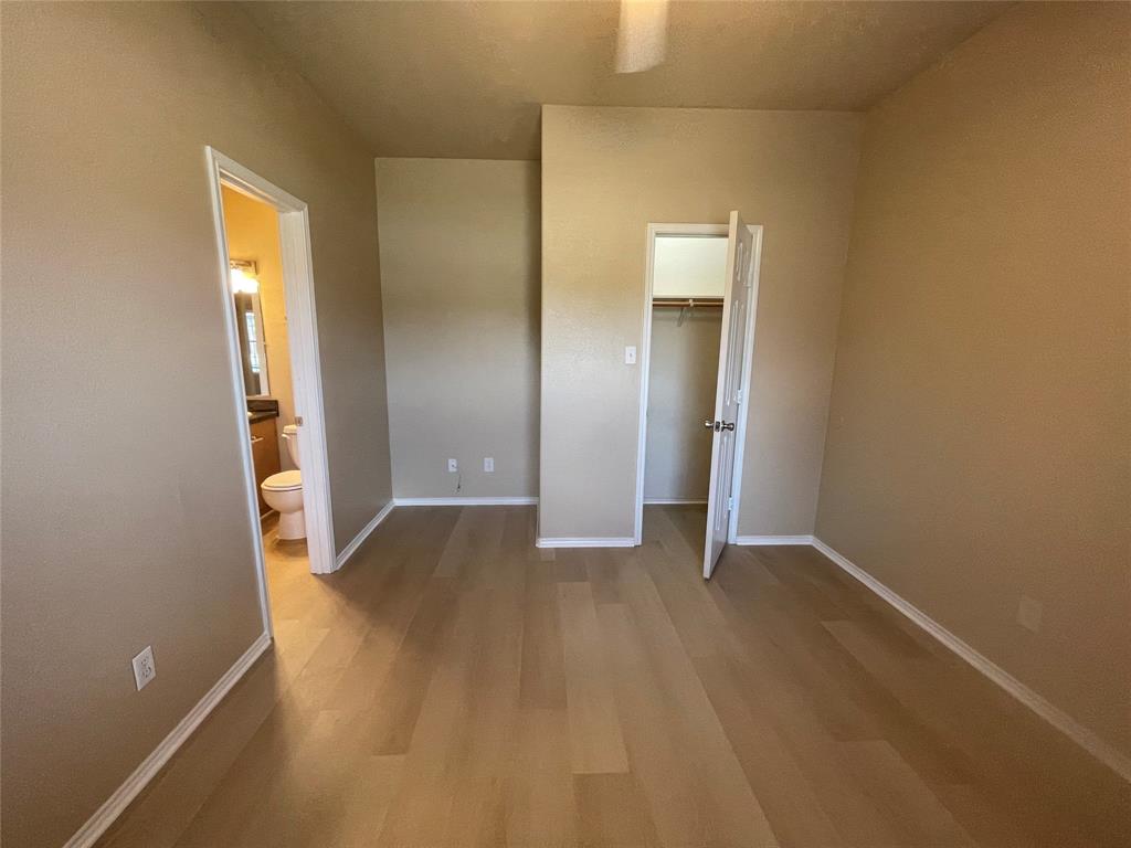 101 Sunburst Court, Unit 107 Weatherford, TX 76087 - Photo 12 of 24 an empty room with closet and mirror
