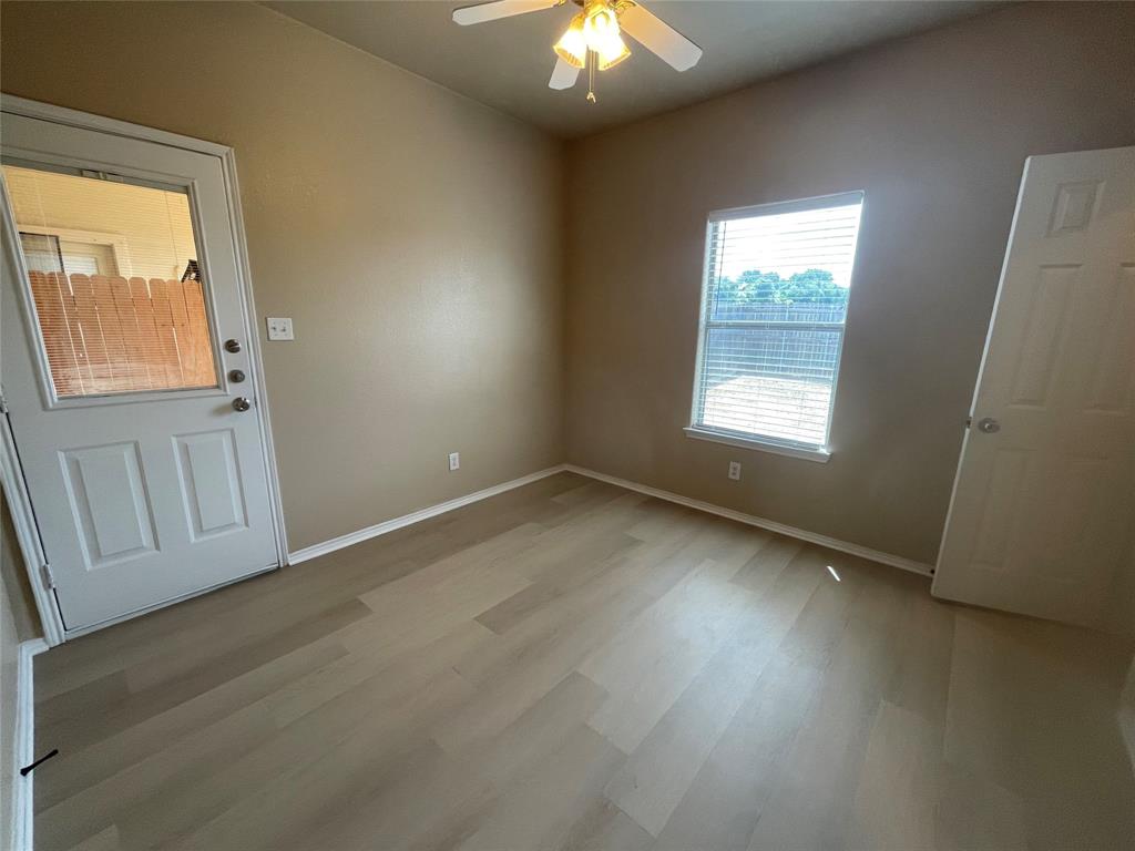 101 Sunburst Court, Unit 107 Weatherford, TX 76087 - Photo 19 of 24 an empty room with wooden floor and windows