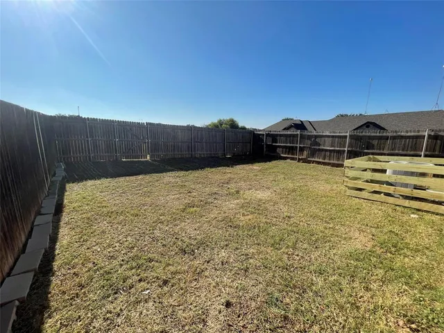 a view of a backyard with wooden fence