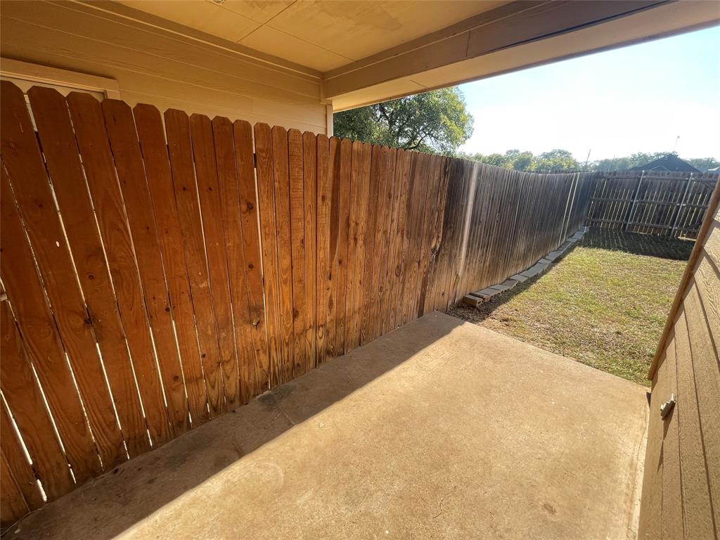101 Sunburst Court, Unit 107 Weatherford, TX 76087 - Photo 23 of 24 a view of a backyard with wooden fence