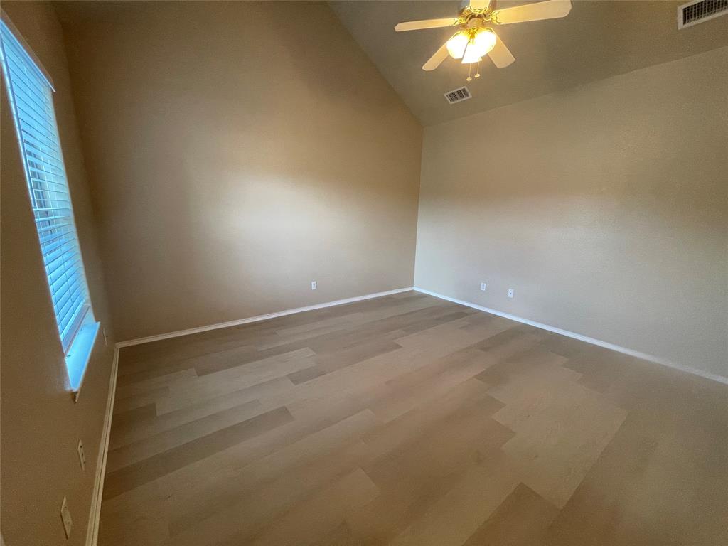 101 Sunburst Court, Unit 107 Weatherford, TX 76087 - Photo 10 of 24 a view of an empty room with a chandelier fan