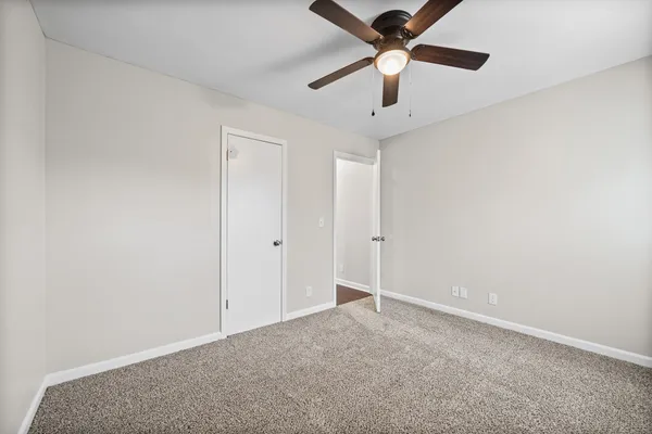 an empty room with a ceiling fan and fan