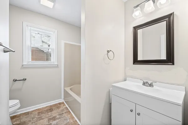 a bathroom with a toilet sink vanity and mirror