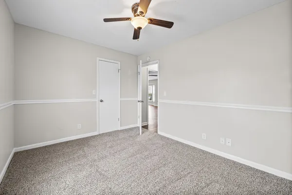 an empty room with closet and windows