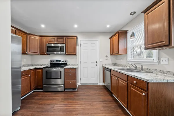 a kitchen with stainless steel appliances granite countertop a sink stove and refrigerator