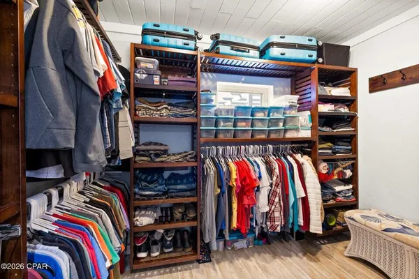 a view of walk in closet with clothes and shoes