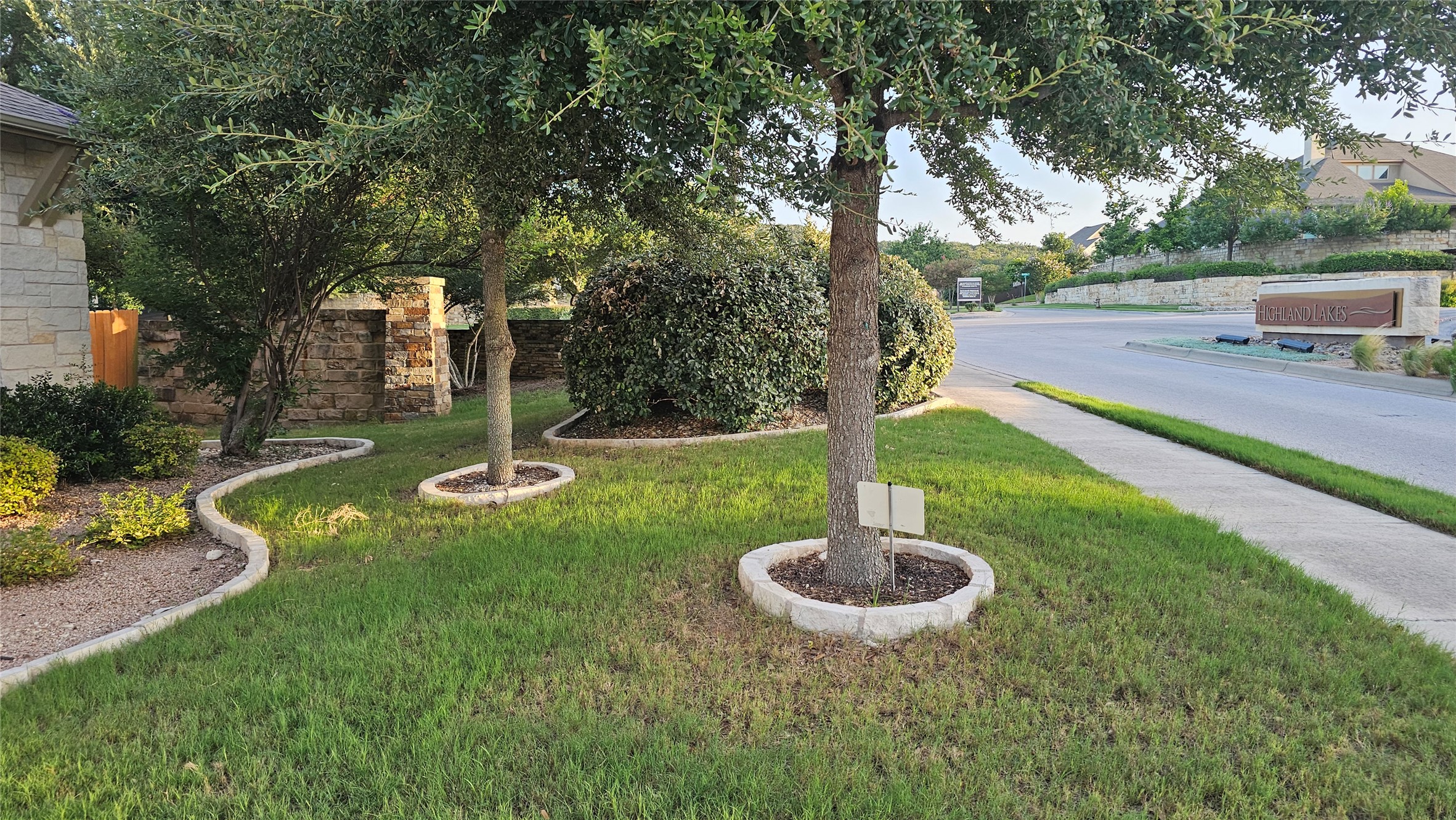 5821 Buchanan Draw Road Austin, TX 78738 - Photo 16 of 18 Manicured landscaping borders the sidewalk leading to a charming community entrance.