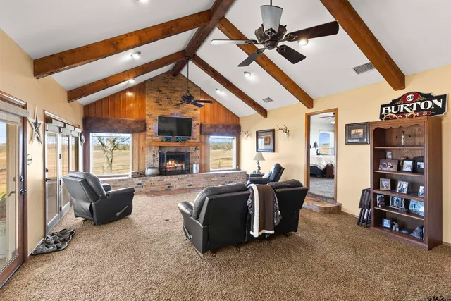a living room with fireplace furniture and a large window