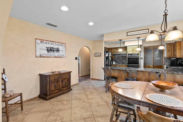 a kitchen with stainless steel appliances granite countertop a sink a stove and a wooden cabinets
