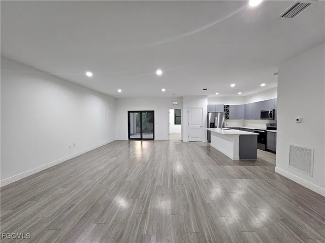 a view of kitchen with kitchen island wooden floor and center island