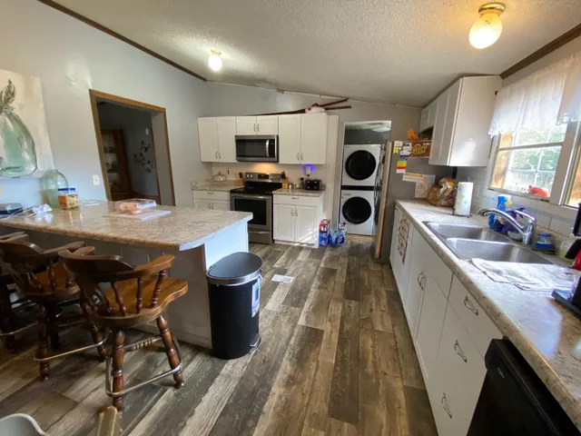 a kitchen with stainless steel appliances kitchen island granite countertop lots of counter top space and furniture