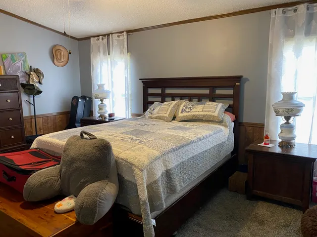a bed sitting in a bedroom next to a window