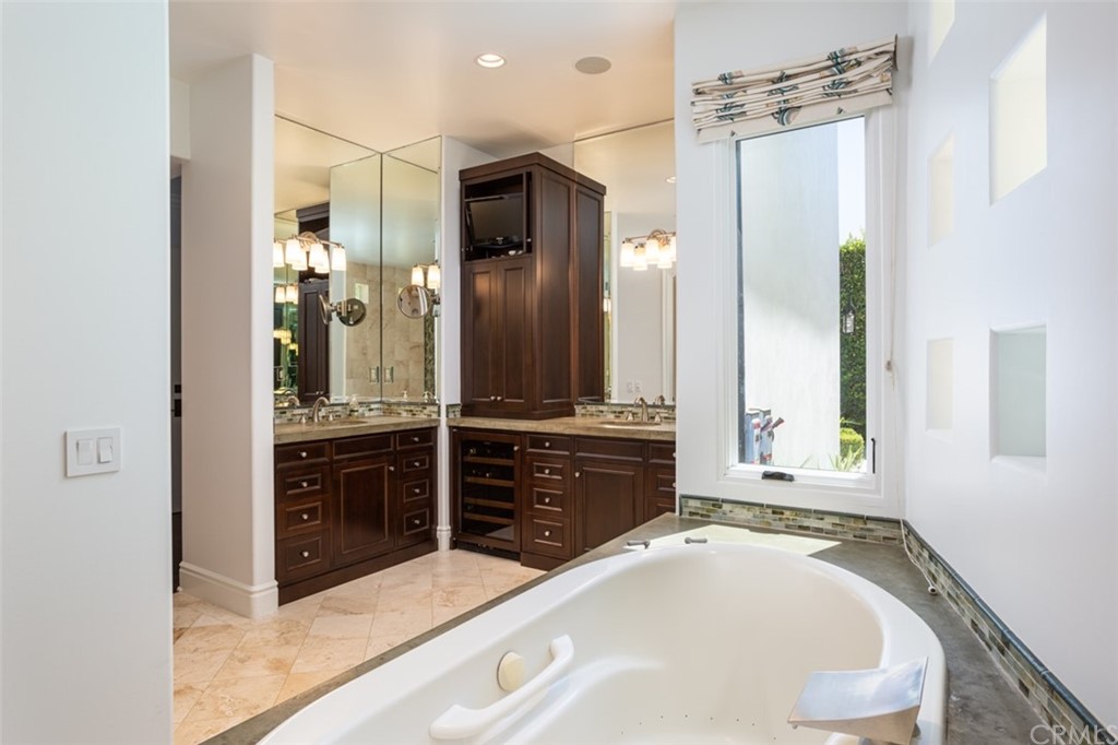 841 Emerald Bay Laguna Beach, CA 92651 - Photo 19 of 31 a spacious bathroom with a granite countertop sink mirror and a bathtub