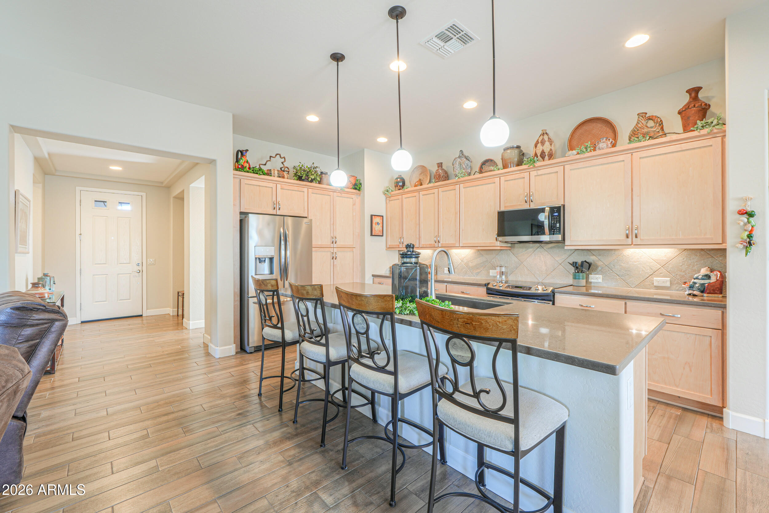 5048 North Scottsdale Road Eloy, AZ 85131 - Photo 7 of 53 a kitchen with stainless steel appliances granite countertop a stove a sink a refrigerator and chairs with wooden floor