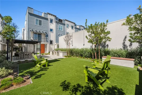 a view of backyard of house with outdoor seating and green space