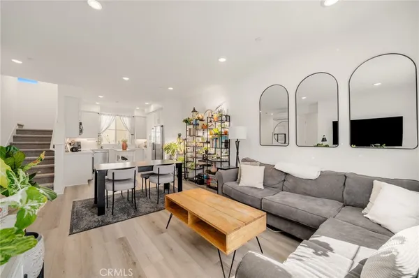 a living room with furniture a chandelier and kitchen view