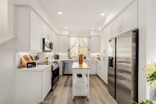 a kitchen with white cabinets and stainless steel appliances