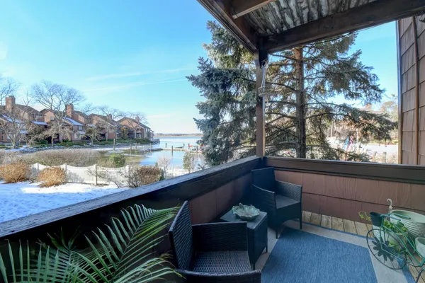 a view of a lake from a balcony with seating space