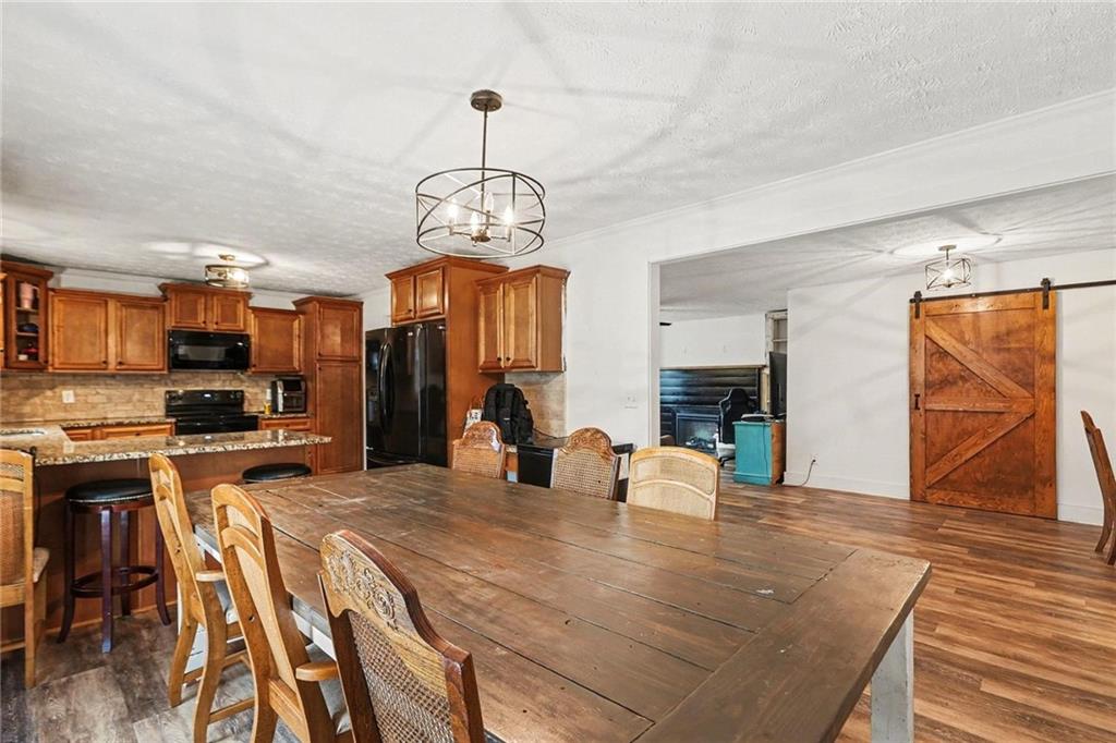 221 Rome Street Temple, GA 30179 - Photo 13 of 30 a view of a dining room and livingroom with furniture wooden floor a chandelier