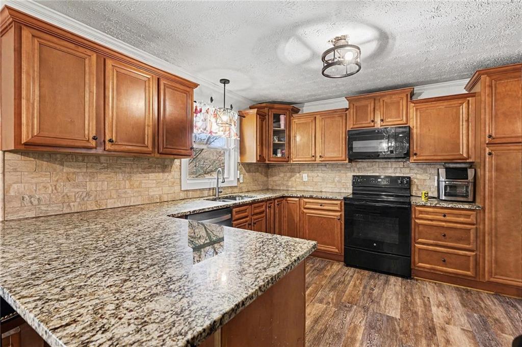 221 Rome Street Temple, GA 30179 - Photo 14 of 30 a kitchen with stainless steel appliances granite countertop a sink stove and refrigerator