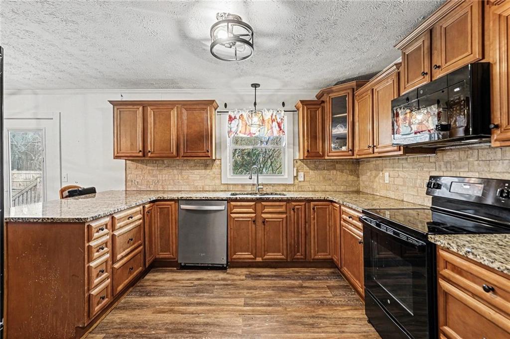 221 Rome Street Temple, GA 30179 - Photo 15 of 30 a kitchen with stainless steel appliances granite countertop a sink stove and cabinets