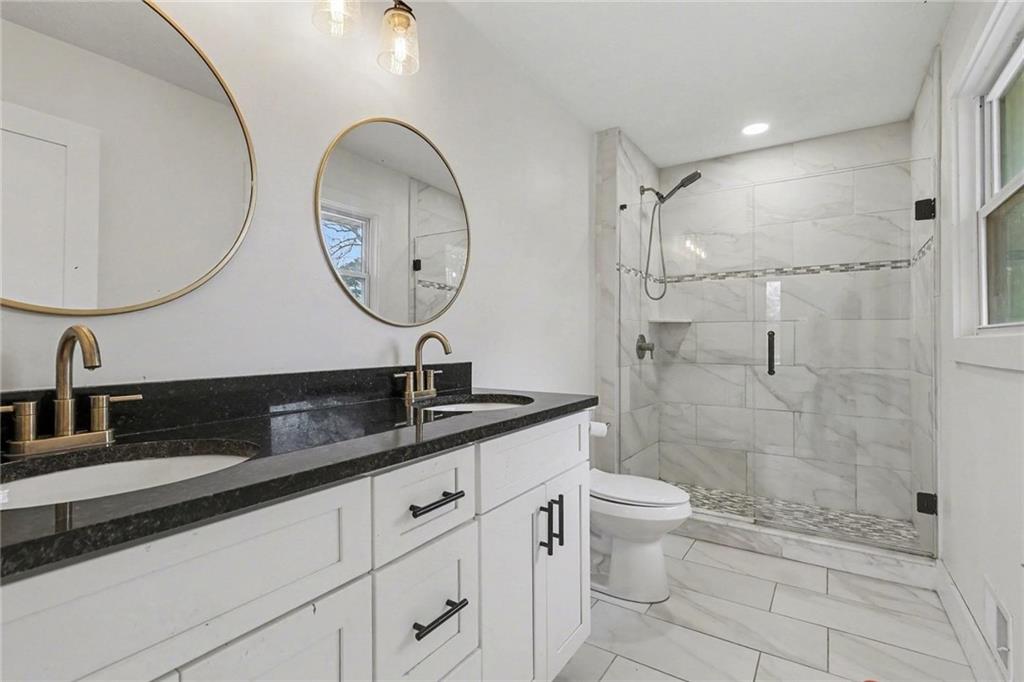 221 Rome Street Temple, GA 30179 - Photo 21 of 30 a bathroom with a double vanity sink toilet and a mirror