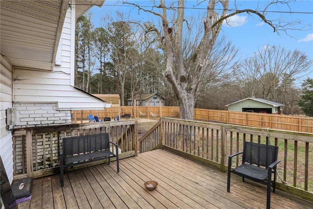 221 Rome Street Temple, GA 30179 - Photo 26 of 30 a view of a roof deck with table and chairs a barbeque with wooden floor and fence