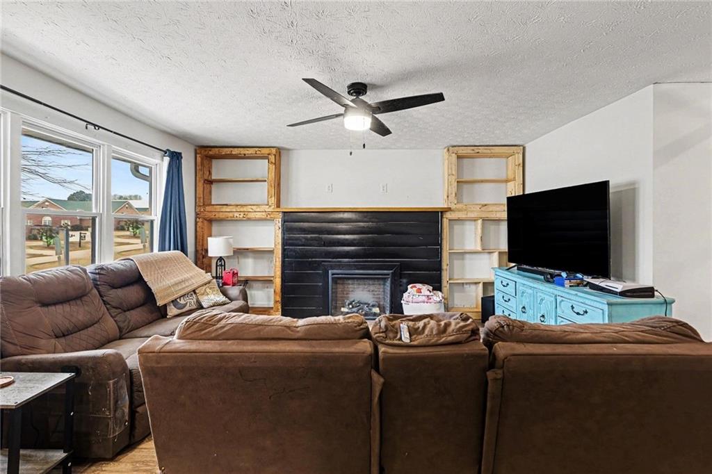 221 Rome Street Temple, GA 30179 - Photo 9 of 30 a living room with furniture a flat screen tv and a fireplace