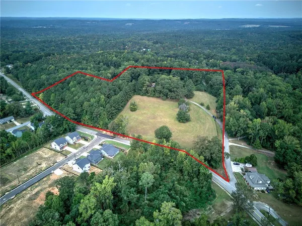 an aerial view of green landscape with trees houses and mountain view