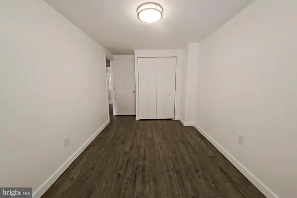 a view of a room with wooden floor and white walls