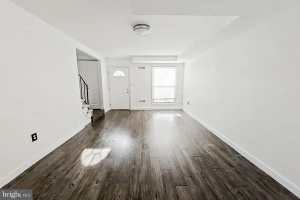 a view of a room with wooden floor and window