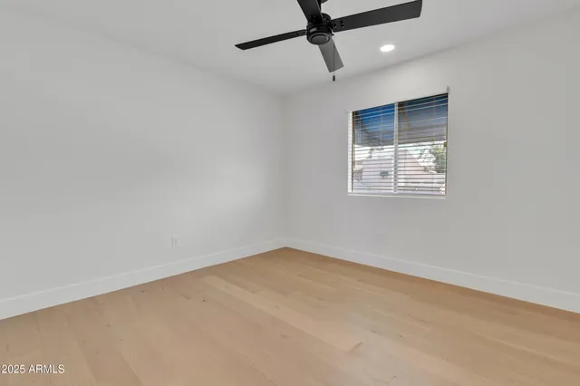 an empty room with a window and a ceiling fan