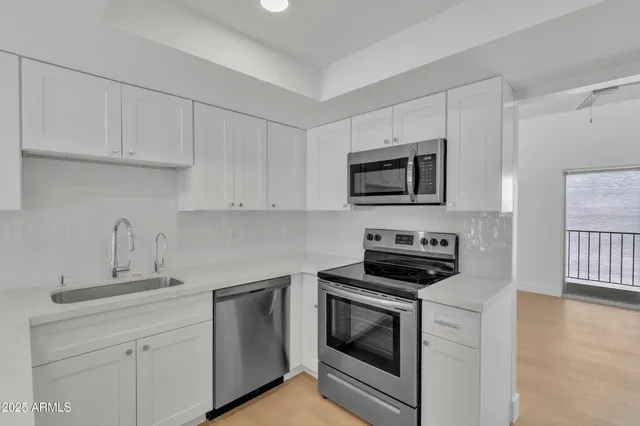 a kitchen with white cabinets stainless steel appliances and sink