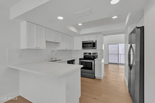 a kitchen with stainless steel appliances a refrigerator stove microwave and cabinets