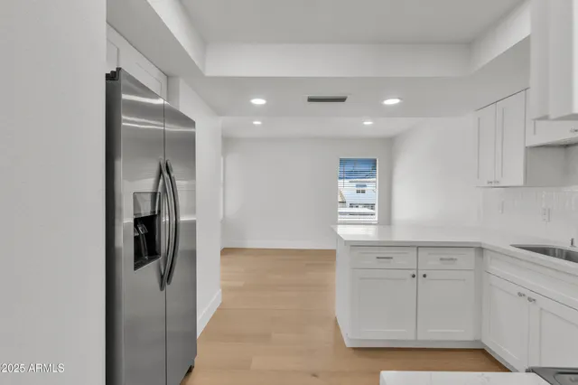 a kitchen with white cabinets and refrigerator