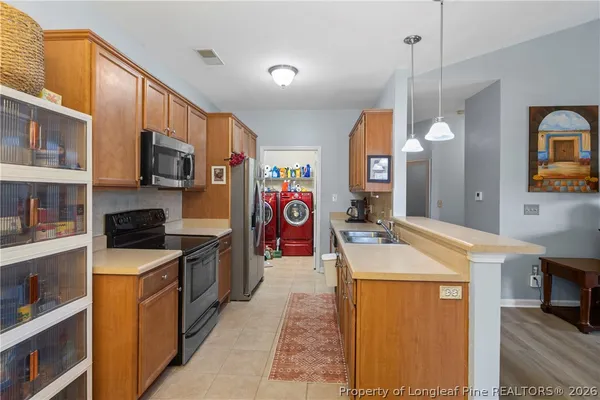 a kitchen with a refrigerator and a stove top oven