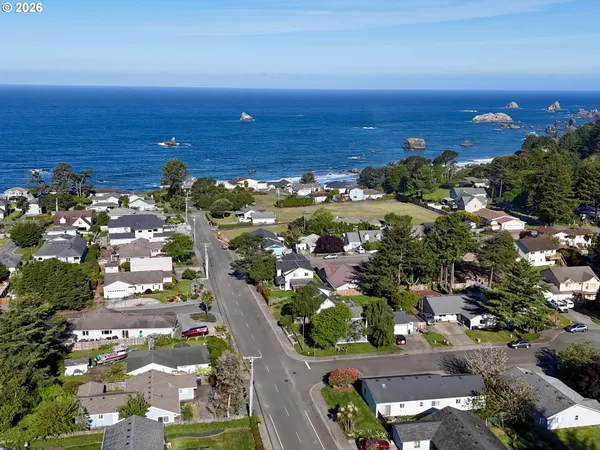 an aerial view of ocean and residential houses with outdoor space
