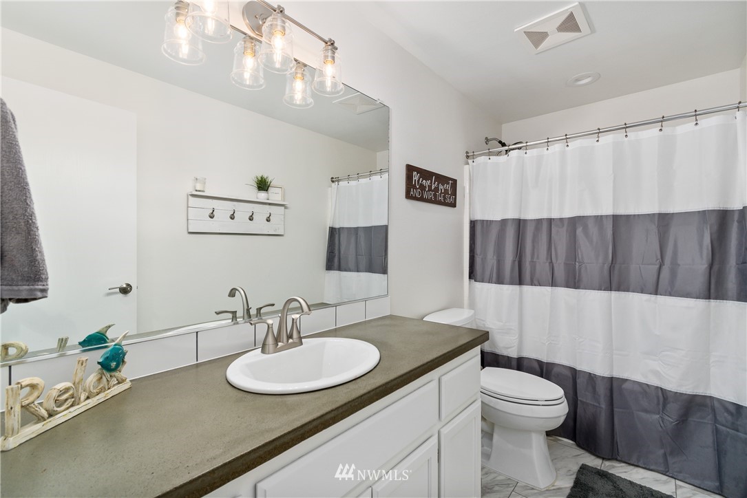 2111 Grove Street Longview, WA 98632 - Photo 19 of 26 a bathroom with a sink a toilet and a mirror