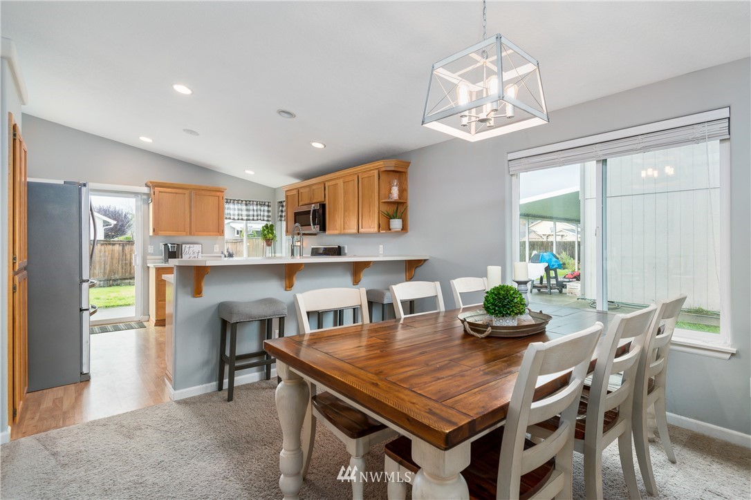 2111 Grove Street Longview, WA 98632 - Photo 7 of 26 a dining room with stainless steel appliances a table chairs and chandelier