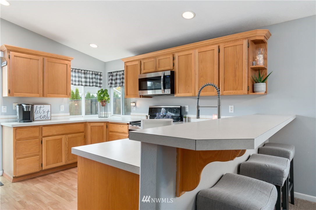 2111 Grove Street Longview, WA 98632 - Photo 9 of 26 a kitchen with stainless steel appliances granite countertop a sink a stove a refrigerator cabinets and chairs