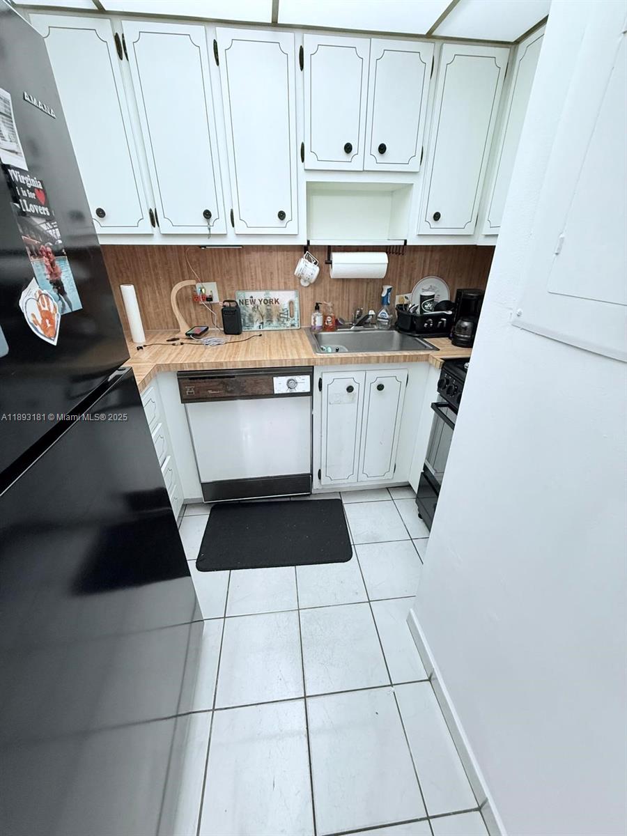 300 Northwest 42nd Avenue, Unit 109 Miami, FL 33126 - Photo 12 of 18 a kitchen with a white cabinets and black appliances